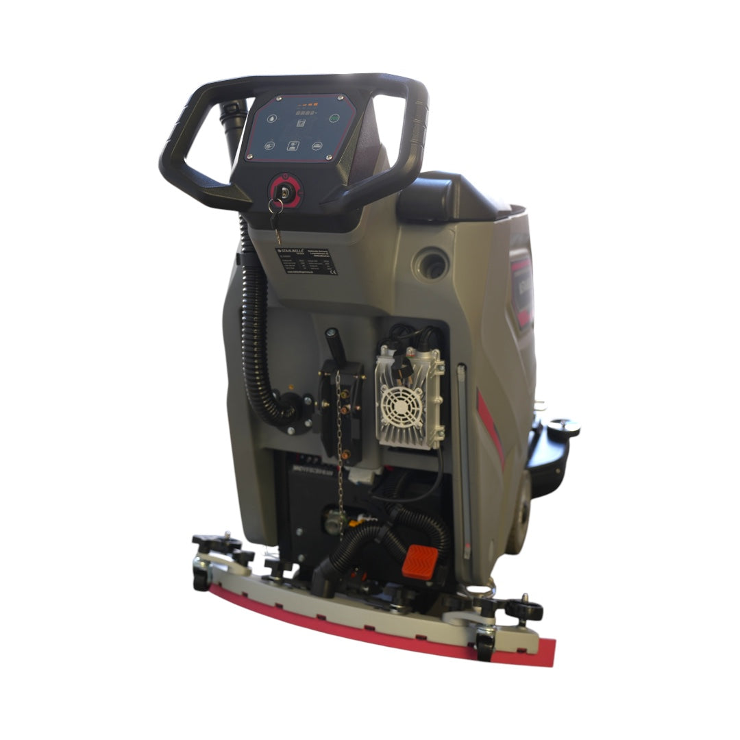 Een grijze Stahlwelle Germany E-500SW schrobzuigmachine, schuin van achteren gefotografeerd tegen een witte achtergrond. De machine heeft een handvat voor bediening, wielen voor transport en een zwarte borstelkop aan de onderzijde. Het Stahlwelle logo en de modelnaam "E-500SW" zijn zichtbaar op de zijkant. Deze compacte schrobzuigmachine is geschikt voor het reinigen van middelgrote oppervlakken.